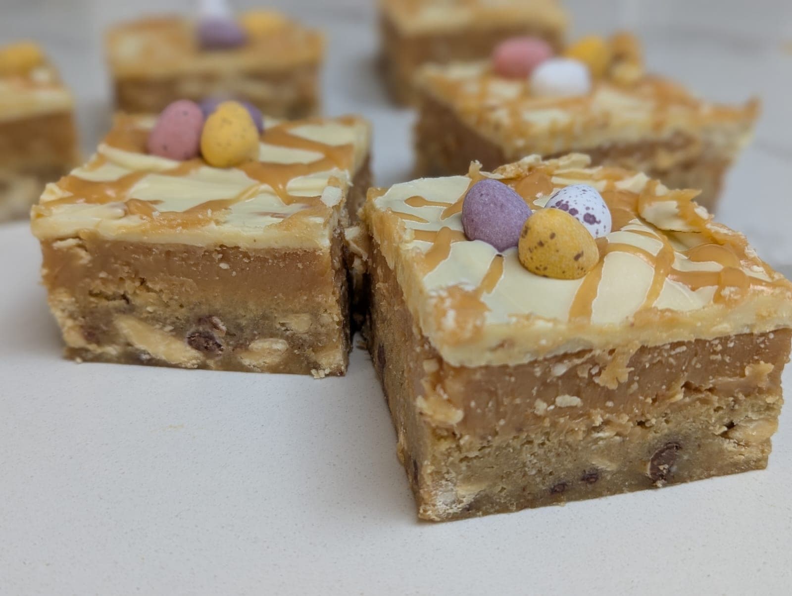 Mini egg billionaires with white chocolate drizzle, caramel and Mini Eggs on top
