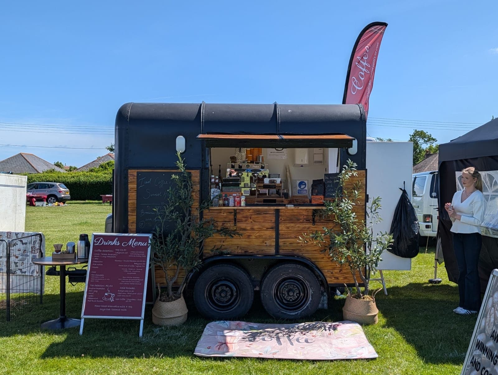 Ahh Roma coffee trailer converted from a horse box, open at a summer event with potted olive trees