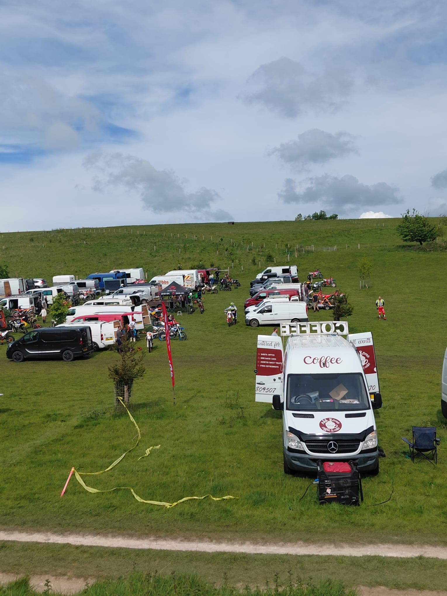 Ahh Roma coffee van parked at a motocross event on a hillside with bikes and vendors around